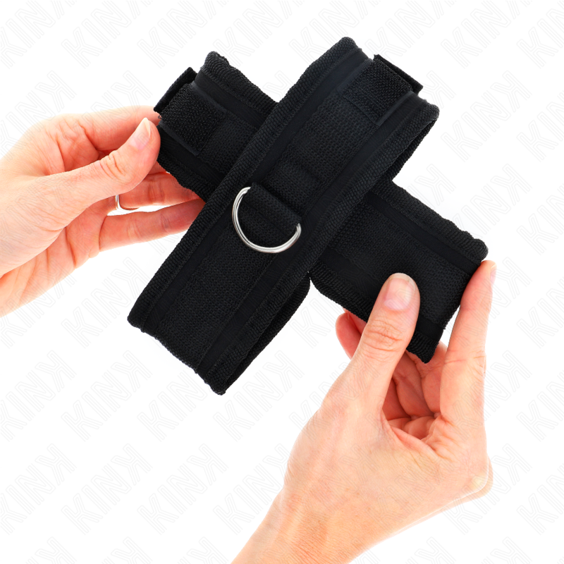 Muñequera cruzada negra de 34 x 5.5 cm de la marca KINK WRIST RESTRAINT, muestra las muñequera con diseño cruzado y cierre ajustable.