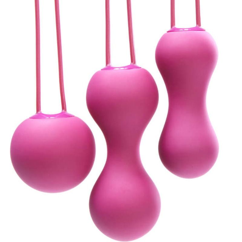 Bolas kegel JE JOUE AMI de color fucsia, diseñadas para ejercicios de fortalecimiento del suelo pélvico, en un fondo neutro.