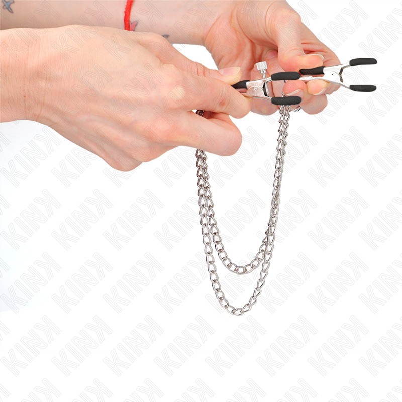 Pinzas para pezones KINK NIPPLE GRIP con doble cadena gruesa en plateado, de 20 a 23 cm, en uso o exhibidas.