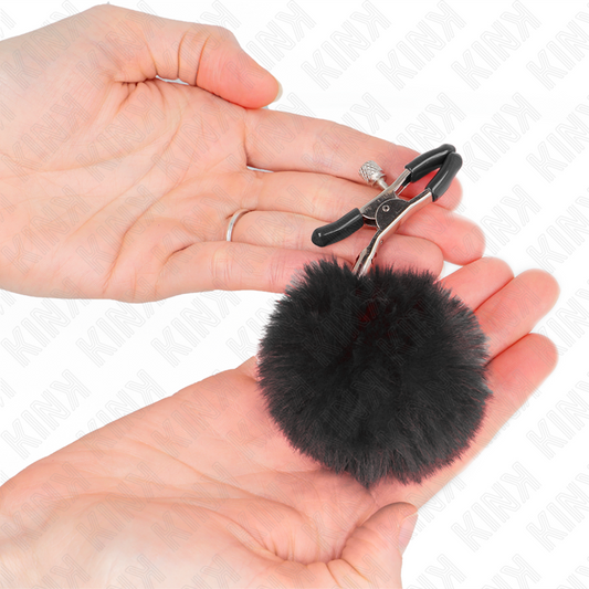 Pinzas para pezones KINK NIPPLE GRIP con pompón negro de 6 cm, hechas de metal y diseño ajustable para estimulación sensorial.