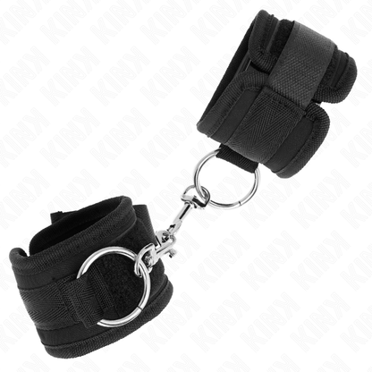 Muñequera ajustable KINK en color negro, de 18-35 cm de longitud y 6 cm de ancho, con cierre seguro y cómodo.