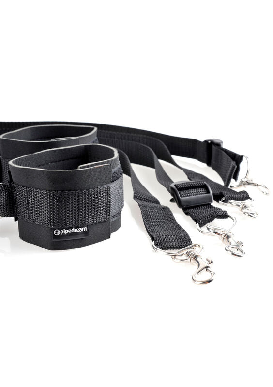 Fetish Fantasy handcuffs and restraints set by Pipedreams displayed on a soft surface, showcasing black straps and metal cuffs.