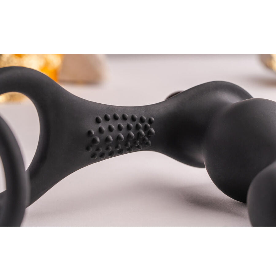 Plug anal con anillo vibrador para pene de la marca ROCKS-OFF, diseño negro, con textura y control de vibración visible en la imagen.